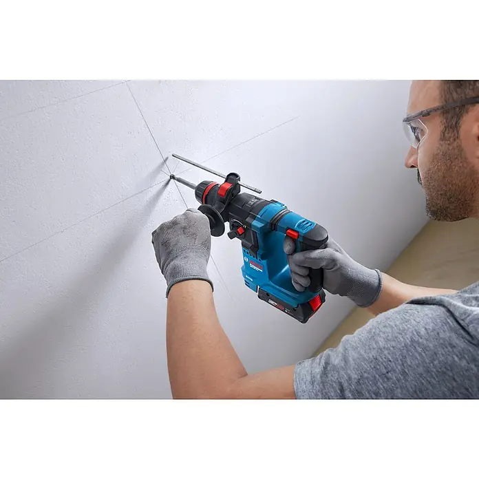 Bosch Professional AMPShare 18V Juego de máquinas - 18 V, 1 batería, 2 Ah, 4 pzs. - Primer plano de un taladro inalámbrico Bosch en acción sobre una pared, perfecto para proyectos de bricolaje y aplicaciones profesionales.