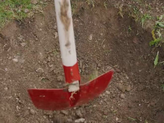 Grube wird im Garten mit einer Schaufel ausgehoben