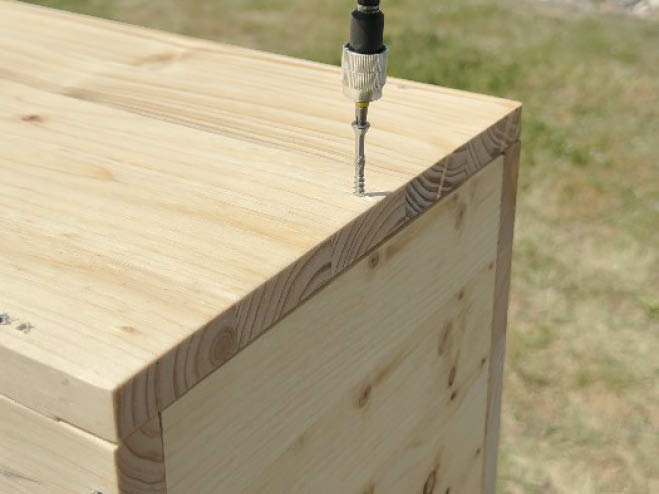 Holzplatten werden zu einem Fensterbeet zusammengeschraubt
