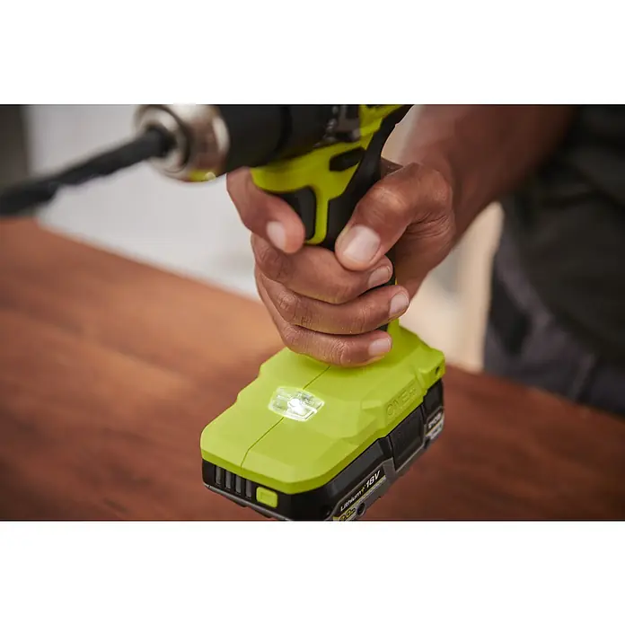 Ryobi ONE+HP Akku-Bohrschrauber-Set RDD18C1-2C40S - 2 Akkus, 4 Ah, 60 Nm, 6 -tlg. - Nahaufnahme eines Ryobi ONE+ Akku-Bohrschraubers mit eingesetztem Bohrer, der von einer Hand gehalten wird und eine integrierte LED-Leuchte hat.