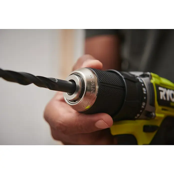 Ryobi ONE+HP Akku-Bohrschrauber-Set RDD18C1-2C40S - 2 Akkus, 4 Ah, 60 Nm, 6 -tlg. - Nahaufnahme einer Ryobi Bohrmaschine mit eingesetztem Bohrer, gehalten von einer Hand, Fokus auf den Bohrkopf und das "Unlock"-Symbol.