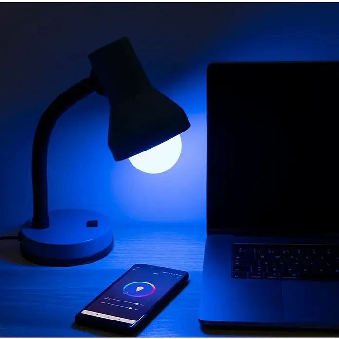 Garza Bombilla LED inteligente Pack - E27, Blanco cálido, 1.060 lm, 11 W - Lámpara de mesa con bombilla LED que cambia de color, controlada por una app de smartphone, junto a un portátil. Diseño moderno con luz azulada.