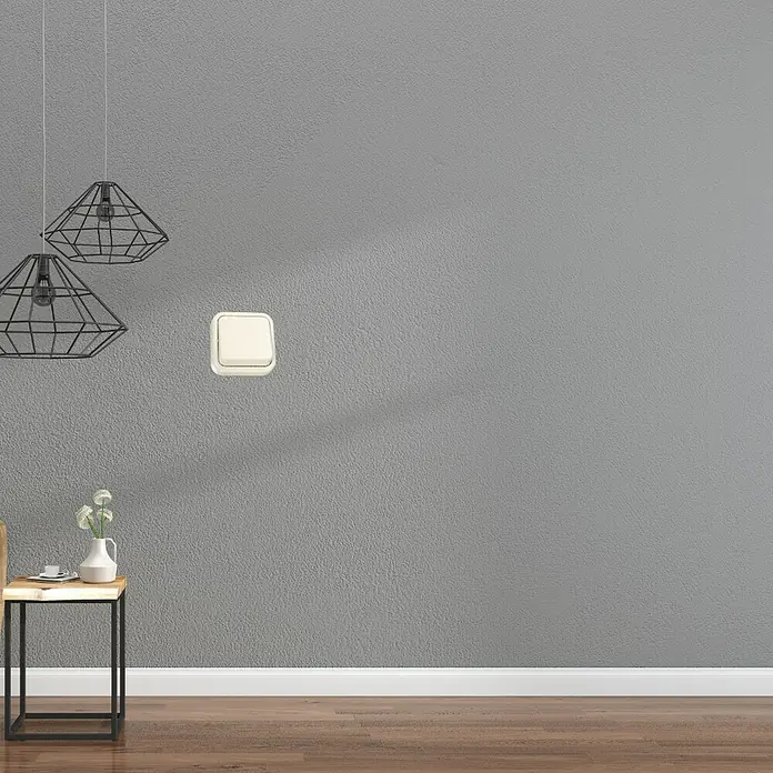 Fontini Kristal Interruptor - Marfil, Colocar, Para interior - Primer plano de un interruptor de luz simple, color crema, sobre una pared gris, que combina funcionalidad con diseño minimalista.