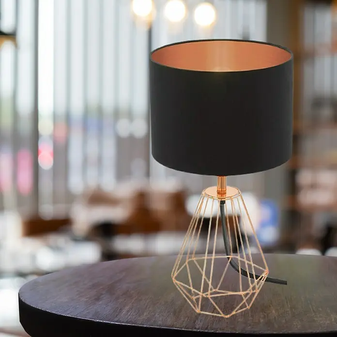 Eglo Carlton 2 Lámpara de sobremesa - 60 W, L x An x Al: 16,5 x 16,5 x 30,5 cm, Rosa dorado, E14 - Lámpara de mesa con pantalla negra y estructura geométrica color cobre sobre una mesa.