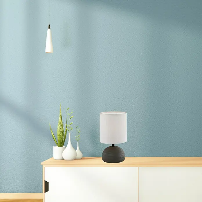 Trio Lighting Lámpara de sobremesa Luci - 40 W, Ø x Al: 14 x 23 cm, Negro, E14 - Elegante lámpara de mesa con pantalla blanca y base oscura sobre una cómoda, junto a plantas decorativas.