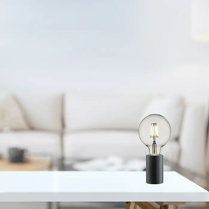 Nordlux Lámpara de sobremesa Siv Mármol - 60 W, L x An x Al: 6 x 6 x 10,3 cm, Negro, E27 - Primer plano de una lámpara de mesa decorativa con bombilla y base negra, sobre una mesa blanca.