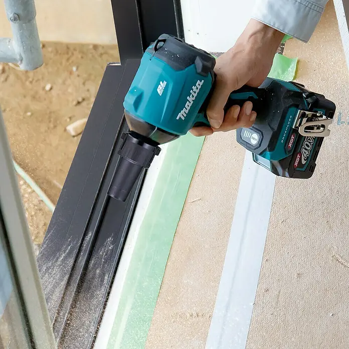 Makita XGT 40V max. Akku-Gebläse AS001GZ - 40 V, Ohne Akku - Nahaufnahme eines Makita-Schlagschraubers mit Akku, der auf einer Baustelle verwendet wird. Ideal für schwere Schraubarbeiten.