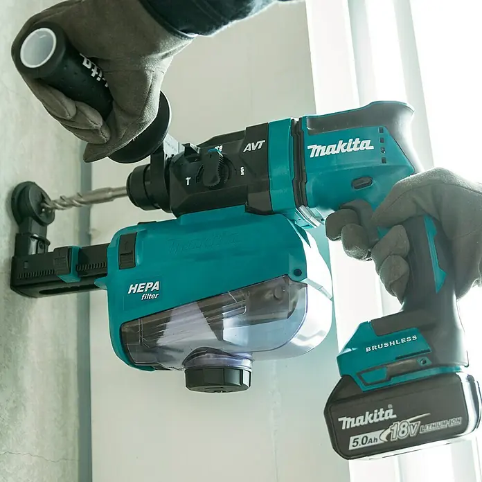 Makita LXT 18V Akku-Kombihammer DHR182Z - 18 V, Ohne Akku, 1,7 J - Nahaufnahme eines Makita Akku-Bohrhammers mit HEPA-Filter und Bohrer, der in eine Wand bohrt.