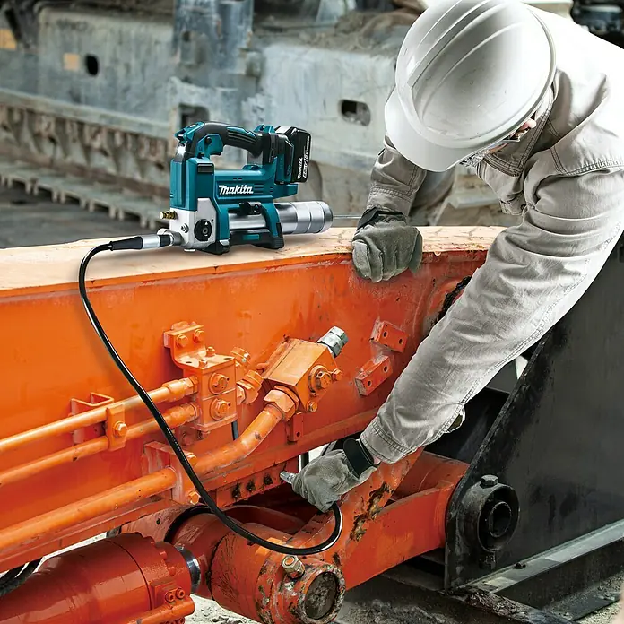 Makita LXT 18V Akku-Fettpresse DGP180Z - 18 V, Ohne Akku - Nahaufnahme einer Makita Fettpresse im Einsatz mit einem Arbeiter in Arbeitskleidung.