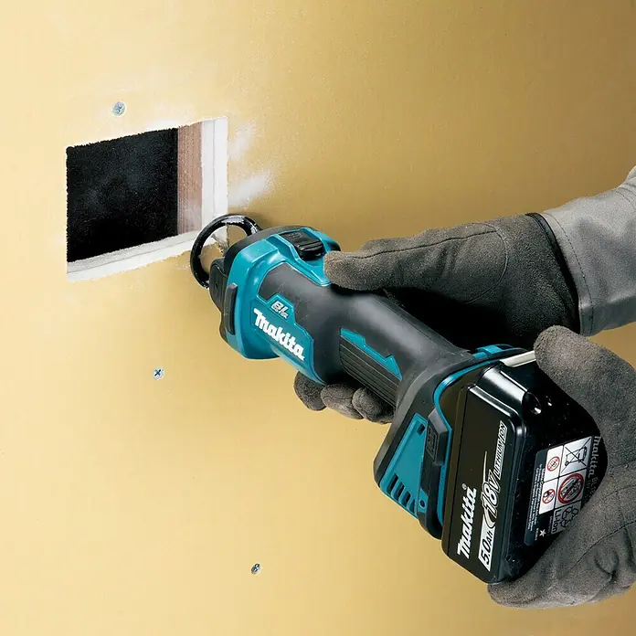 Makita LXT 18V Akku-Rotationswerkzeug DCO181Z - 18 V, Ohne Akku, Leerlaufdrehzahl: 32.000 U/min - Akkuschere Makita, Modell X2, schneidet ein Loch in eine Wand. Der Akku ist 18V und 5.0Ah für kraftvolles Arbeiten.