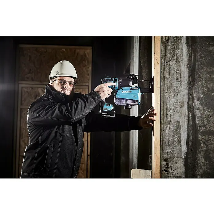 Makita LXT 18V Akku-Kombihammer DHR182Z - 18 V, Ohne Akku, 1,7 J - Ein Bauarbeiter mit Schutzhelm bohrt mit einem Makita Akku-Bohrhammer mit Staubabsaugung ein Loch in eine Betonwand.
