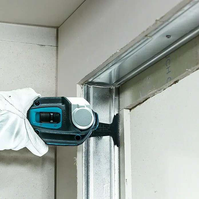 Makita XGT 40V max. Akku-Multifunktionswerkzeug ‎TM001GZ - 40 V, Ohne Akku - Ein Werkzeug zum Schneiden von Metallprofilen, das von einer Hand mit einem Schutzhandschuh bedient wird. Das Gerät ist kompakt und präzise.