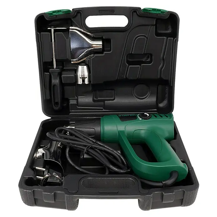 Stayer Pistola de aire caliente SUH2000EK - 2.000 W, 50 °C - 600 °C - Una pistola de calor verde STAYER en un maletín de herramientas negro con accesorios de boquilla.