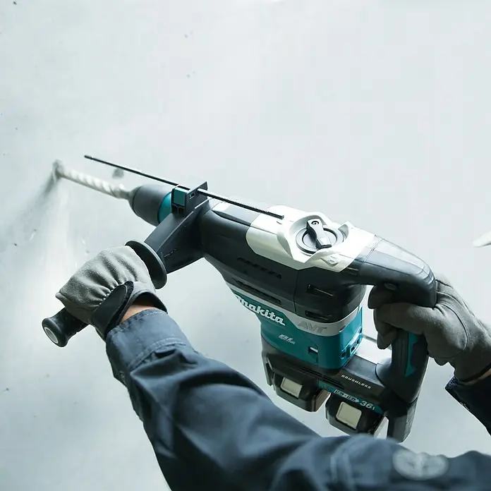 Makita LXT 18V Akku-Kombihammer DHR400ZKUN - 36 V, Ohne Akku, 8 J - Makita Akku-Bohrhammer im Einsatz, der mühelos durch eine Wand bohrt, gehalten von einer Person mit Arbeitshandschuhen.