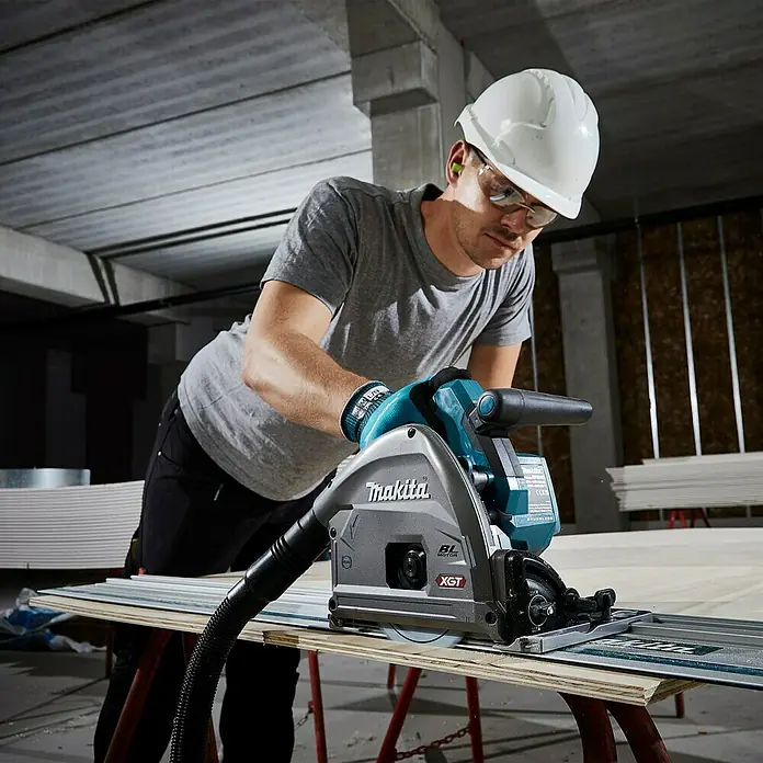 Makita XGT 40V max. Akku-Tauchsäge im MAKPAC SP001GZ03 - 40 V, Ohne Akku, Durchmesser Sägeblatt: 165 mm, 2.500 U/min - Ein Bauarbeiter benutzt eine Makita Tauchsäge XGT zum Schneiden von Holz, um präzise Schnitte zu gewährleisten.