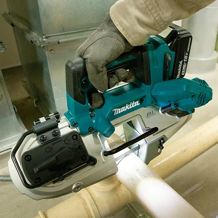 Makita LXT 18V Akku-Bandsäge DPB183Z - 18 V, Ohne Akku - Nahaufnahme einer Makita Akku-Bandsäge beim Schneiden eines Rohrs, fokussiert auf Präzision und Leistung des Werkzeugs.