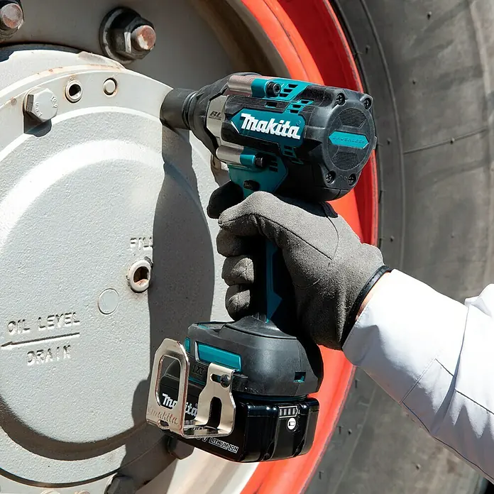 Makita LXT 18V Akku-Schlagschrauber DTW701Z + Artikelnr. 33855482 hinzufügen* - 18 V, Ohne Akku, 700 Nm - Ein Makita Akku-Schlagschrauber beim Festziehen einer Schraube an einem Rad. Hochwertiges Werkzeug für professionelle Anwendungen.