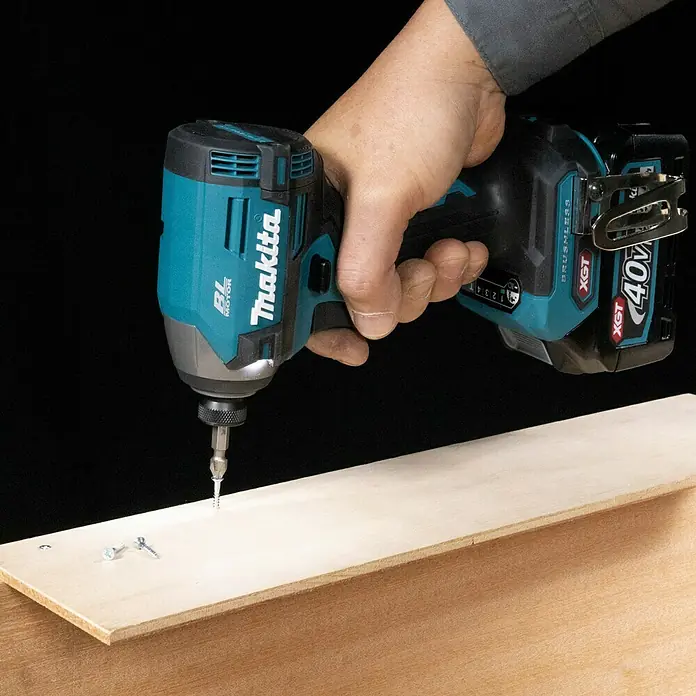 Makita XGT 40V max. Akku-Schlagschrauber TD003GZ - 40 V, Ohne Akku, 210 Nm - Nahaufnahme eines Makita XGT Akku-Schlagschraubers beim Eindrehen einer Schraube in ein Holzbrett.