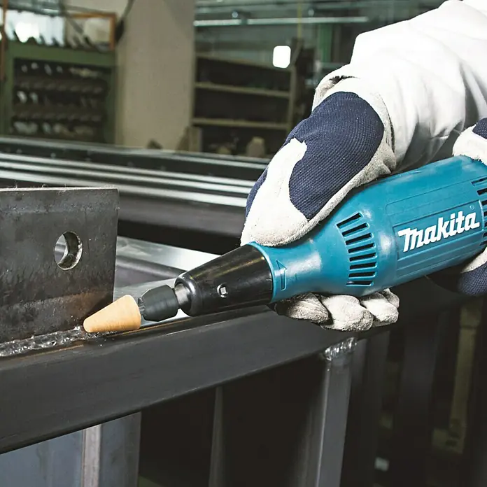 Makita Geradschleifer GD0603 - 240 W, Leerlaufdrehzahl: 28.000 U/min - Bild einer Makita-Schleifmaschine bei der Arbeit, ideal für Metallbearbeitung. Das handliche Werkzeug sorgt für präzise Ergebnisse.