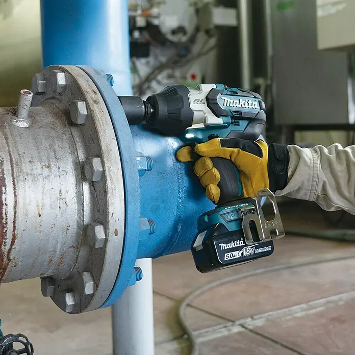 Makita LXT 18V Akku-Schlagschrauber DTW1004Z - 18 V, Ohne Akku, 4 Ah, 1.050 Nm - Der Makita Akku-Schlagschrauber bei der Arbeit an einer großen Rohrverbindung, ideal für schwere Schraubarbeiten.