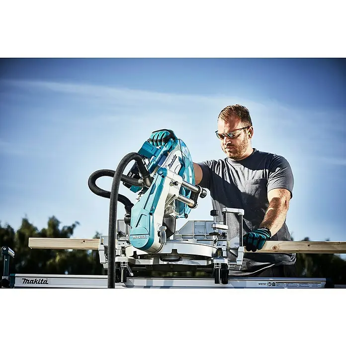 Makita LXT 18V Akku-Kapp- & Gehrungssäge DLS211ZU - 36 V, Ohne Akku - Ein Mann bedient eine Makita-Kapp- und Gehrungssäge mit Staubabsaugung beim Zuschneiden eines Holzstücks.