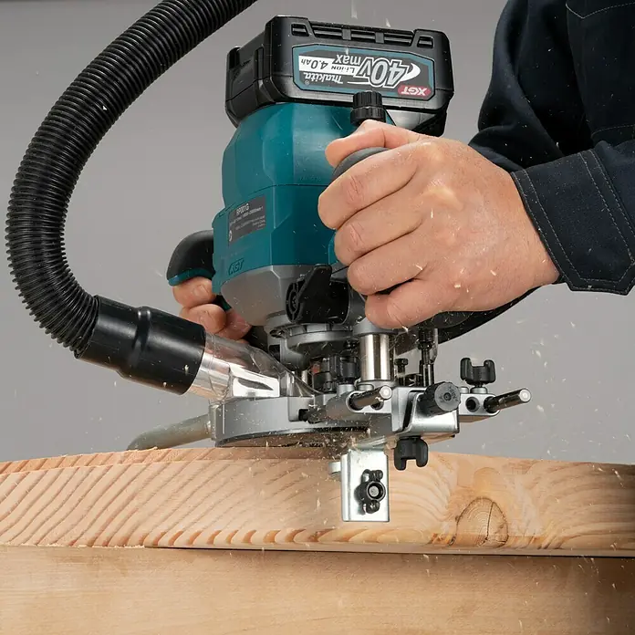 Makita Oberfräse RP001GZ - 40 V, 1 Akku - Nahaufnahme einer Makita Oberfräse bei der Holzbearbeitung mit Staubabsaugung. Ideal für präzise Holzarbeiten.