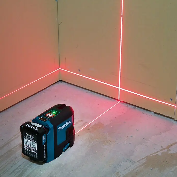 Makita CXT 12V max. Kreuzlinienlaser SK105DZ - 12 V, Ohne Akku, Max. Arbeitsbereich: 25 m - Makita Kreuzlinienlaser mit klaren roten Linien projiziert auf Wände und Boden, ideal für präzise Ausrichtung.