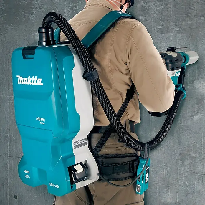 Makita LXT 18V Akku-Rucksackstaubsauger DVC665ZU - 36 V, Ohne Akku, Behältervolumen: 6 l, Mit Beutel - Ein Handwerker trägt einen Makita Akku-Rückensauger. Der Sauger ist blau und weiß und hat einen HEPA-Filter.