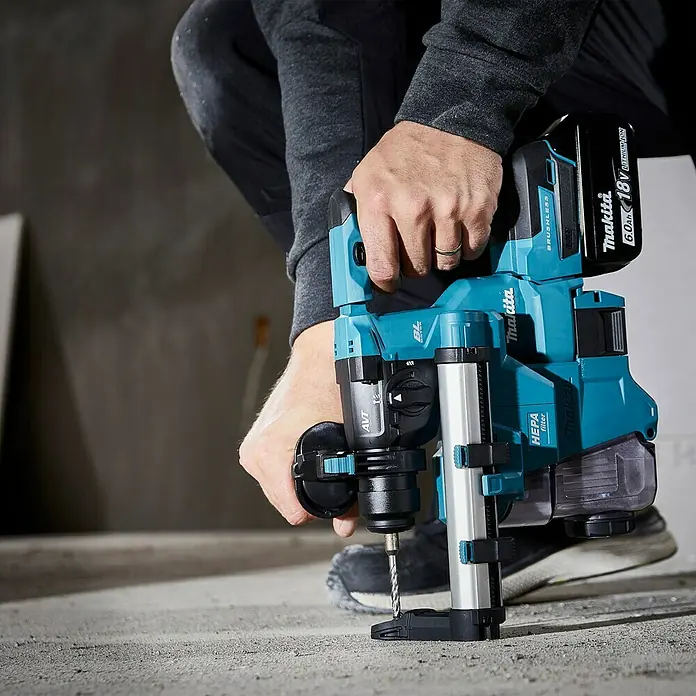 Makita LXT 18V Akku-Bohrhammer DHR183Z - 18 V, Ohne Akku, 1,7 J - Ein Handwerker benutzt einen Makita Akku-Bohrhammer mit HEPA Filter zum Bohren in Beton. Das Gerät ist blaugrün mit einem schwarzen Akku.