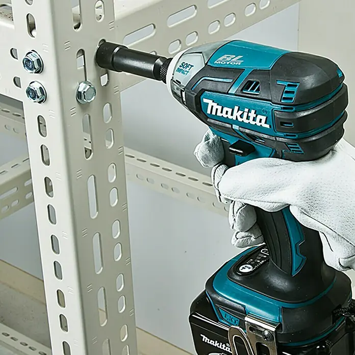 Makita LXT 18V Akku-Impulsschrauber DTS141Z - 18 V, Ohne Akku, 40 Nm - Makita Akku-Schlagschrauber im Einsatz beim Festziehen einer Schraube. Das Werkzeug ist blaugrün und schwarz mit einem robusten Design.