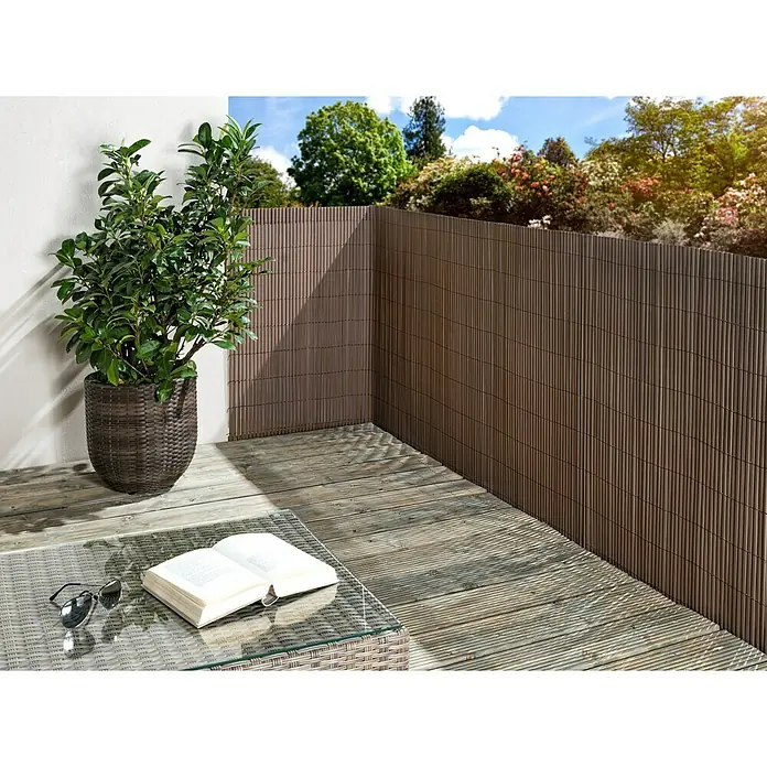 Sichtschutzmatte Comfort - 300 x 90 cm, Kunststoff, Taupe - Elegante braune Sichtschutzwand aus Bambus auf einer Terrasse mit Tisch und Pflanze, die Privatsphäre und Stil im Außenbereich bietet.