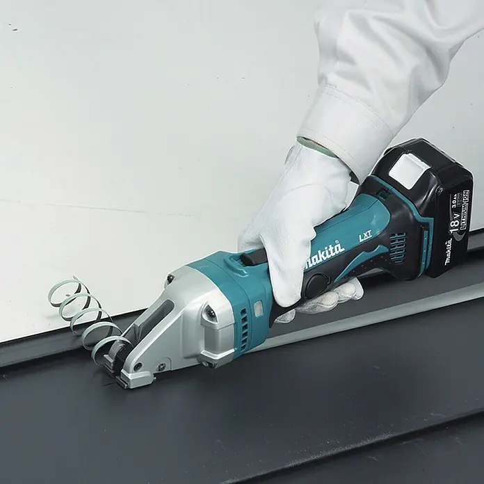 Makita LXT 18V Akku-Blechschere DJS161Z - 18 V, Ohne Akku, Leerlaufhubzahl: 4.300 /min - Akkuschere von Makita beim Schneiden von Metall, wodurch eine spiralförmige Späne entsteht. Das Werkzeug wird von einer Hand mit Schutzhandschuh geführt.