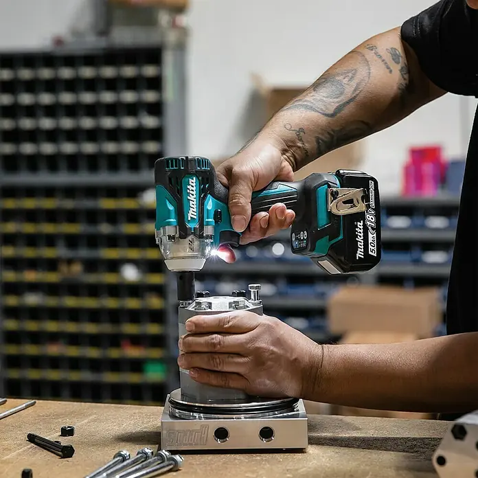 Makita LXT 18V Akku-Schlagschrauber DTW302Z - 18 V, Ohne Akku, 300 Nm - Nahaufnahme einer Person, die einen Akku-Schlagschrauber Makita verwendet, um an einem Metallstück zu arbeiten.