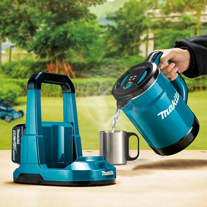Makita LXT 18V Wasserkocher Akku DKT360Z - 18 V, Ohne Akku - Makita Akku-Wasserkocher und Ladestation im Freien. Wasser wird in eine Tasse gegossen, um die Funktionalität zu demonstrieren.