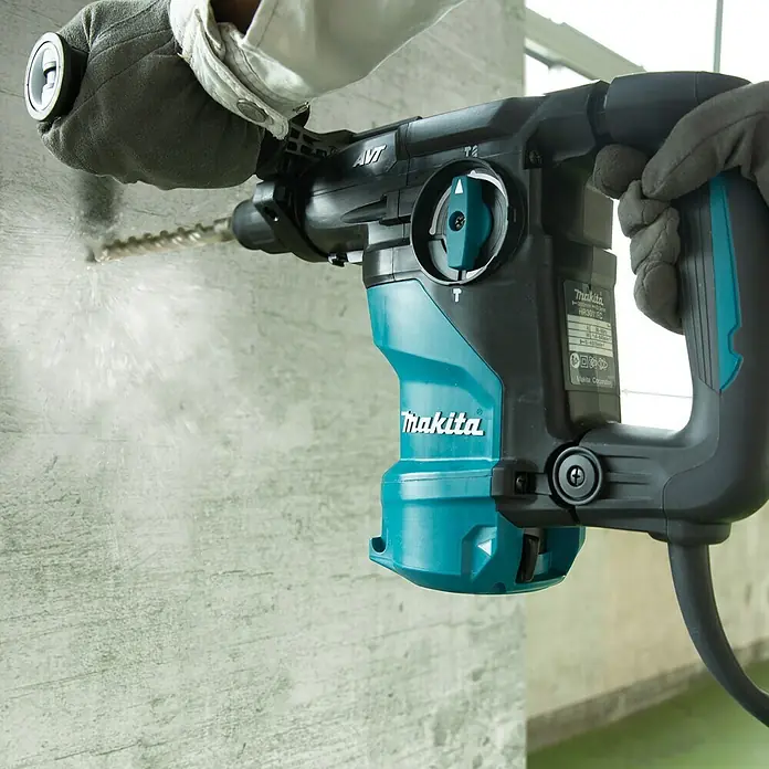 Makita Kombihammer HR3011FCJ - 1.050 W, 3,9 J, SDS-Plus-Aufnahme - Ein Makita Bohrhammer HR3011FC in Aktion, der durch eine Betonwand bohrt. Er bietet hohe Leistung und Komfort bei Bauarbeiten.