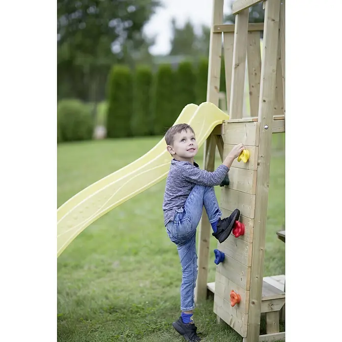 Wendi Toys Kinderspielturm Giraffe - Natur/Gelb - Ein kleiner Junge klettert an einer Kletterwand an einem Spielplatzgerät mit gelber Rutsche im Hintergrund.