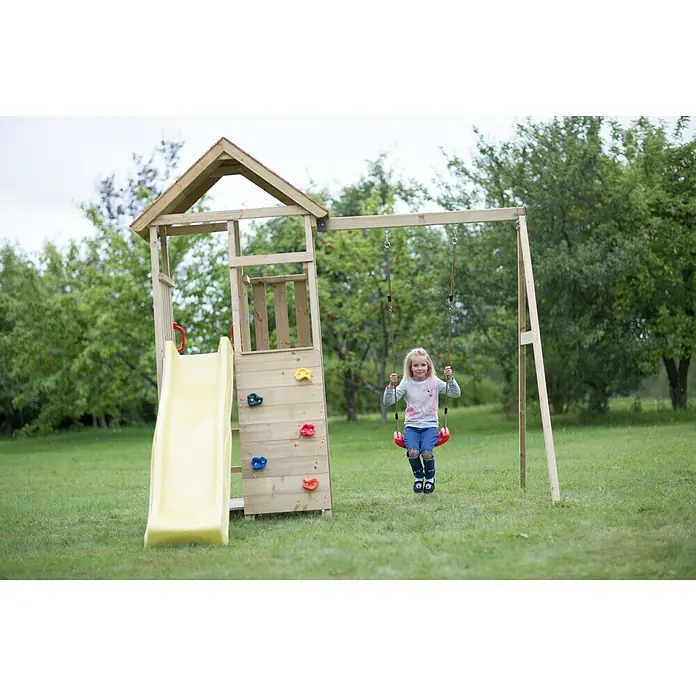Wendi Toys Kinderspielturm Pelikan - Natur/Gelb - Ein Spielplatz mit Rutsche, Kletterwand und Schaukel. Das Kind schwingt fröhlich auf der Schaukel in der grünen Umgebung.