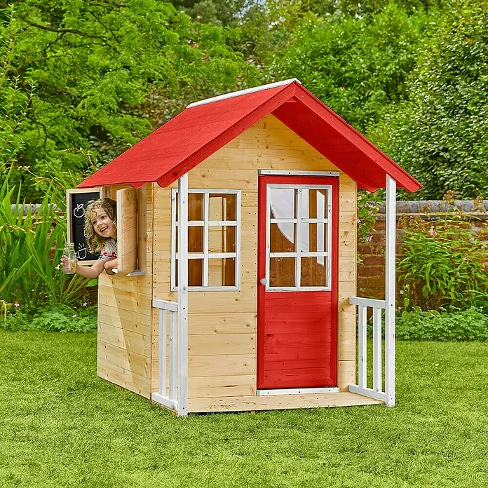 Zwerkules Spielhaus Lolla - L x B x H: 139 x 120 x 139 cm, Holz, Natur/Rot, Ohne Stelzen - Ein helles Holzspielhaus mit rotem Dach und Tür, mit einem spielenden Kind, steht auf einem grünen Rasen.
