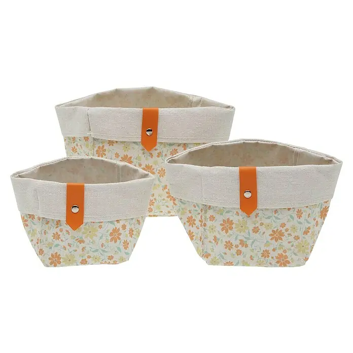 Versa Juego de cestas - Flores naranja, 3 ud. - Conjunto de tres cestas de tela con estampado floral y detalles naranjas, ideales para almacenamiento y decoración.