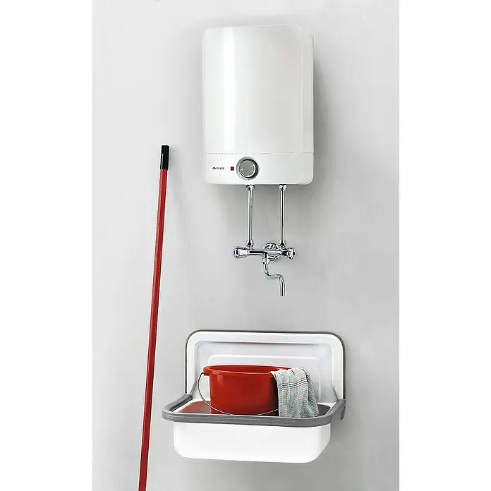 Clage Warmwasserspeicher S10-O - 10 l, 2.200 W, Obertischmontage - Eine weiße Küchenspüle mit einem roten Eimer und einem Lappen darunter, darüber ein Warmwasserbereiter und eine Armatur an einer weißen Wand.