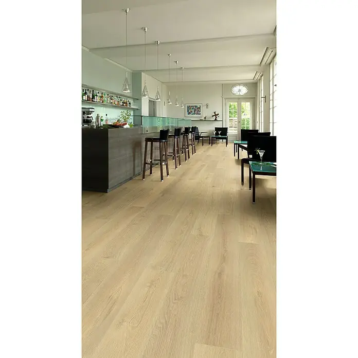 Krono Original Laminat Organic Clever Long Silent - Blonde Montreux Oak, Landhausdiele, 2.003 x 245 x 7 mm - Innenaufnahme eines Raumes mit einem hellen Holzboden, einer Bar mit Barhockern und Sitzgelegenheiten. Eine gemütliche Atmosphäre mit Stil.