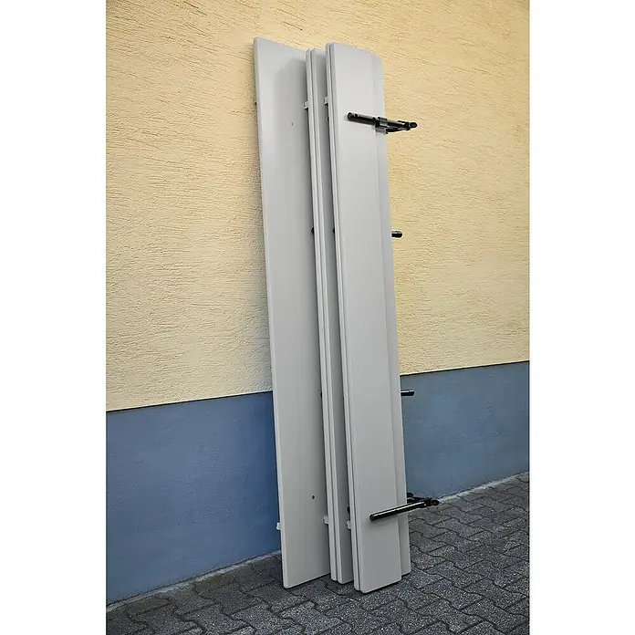 Bierzeltgarnitur - 3 -tlg., Fichte/Stahl, Klappbar, Beige/Grau, Tisch (L x B x H): 220 x 70 x 77 cm, Bank (L x B): 220 x 30 cm - Drei weiße Fensterläden lehnen an einer Wand, mit schwarzen Halterungen zur Befestigung am Fensterrahmen. Die Läden sind sauber und modern.