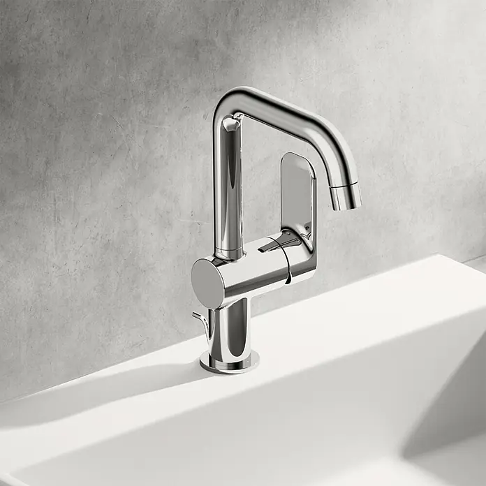 Hansa Pico Waschtischarmatur - Chrom, Mit Ablaufgarnitur - Nahaufnahme eines glänzenden, modernen Wasserhahns auf einem weißen Waschbecken vor einer grauen Wand.