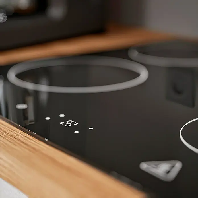 Respekta Composición de cocina Hilde - Ancho: 280 cm, Blanco, Con electrodomésticos - Primer plano de una placa de vitrocerámica negra con panel de control y zonas de cocción, empotrada en una encimera de madera.