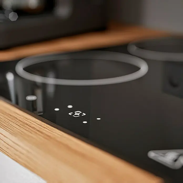 Respekta Composición de cocina Hilde - Ancho: 310 cm, Blanco, Con electrodomésticos - Primer plano de una moderna placa de cocina negra con panel de control y marcas de los fogones. Diseño elegante para una cocina contemporánea.