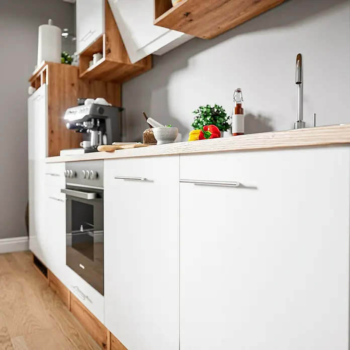 Respekta Composición de cocina Hilde - Ancho: 280 cm, Blanco, Con electrodomésticos - Vista de cocina con armarios blancos, un fregadero y una encimera de madera. Varios utensilios de cocina están encima de la encimera.