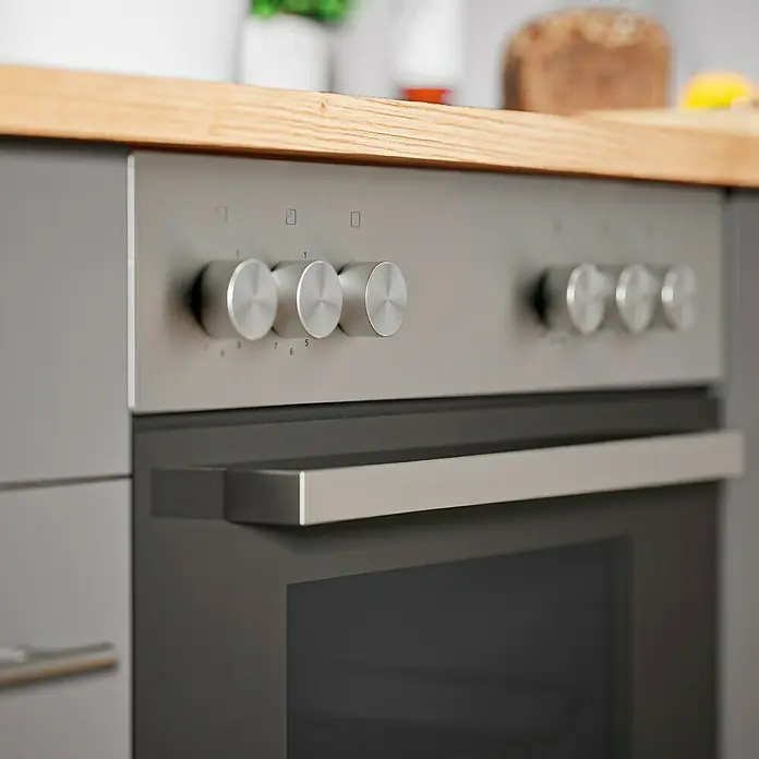 Respekta Composición de cocina Hilde - Ancho: 310 cm, Gris, Con electrodomésticos - Primer plano de un horno de cocina gris moderno con perillas y manija plateadas, destacando su diseño elegante y funcionalidad.