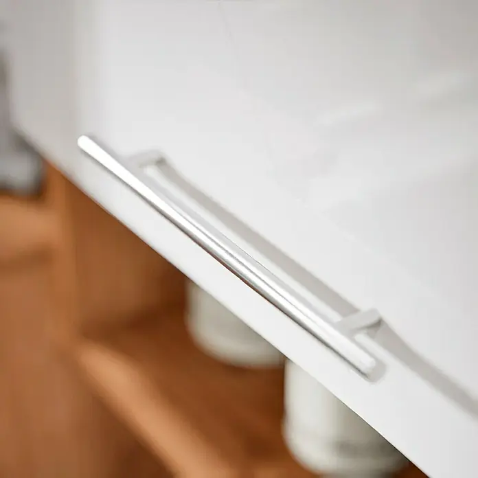 Respekta Composición de cocina Hilde - Ancho: 250 cm, Blanco, Con electrodomésticos - Primer plano de un moderno tirador de armario plateado sobre una puerta de cocina blanca, destacando el diseño elegante.
