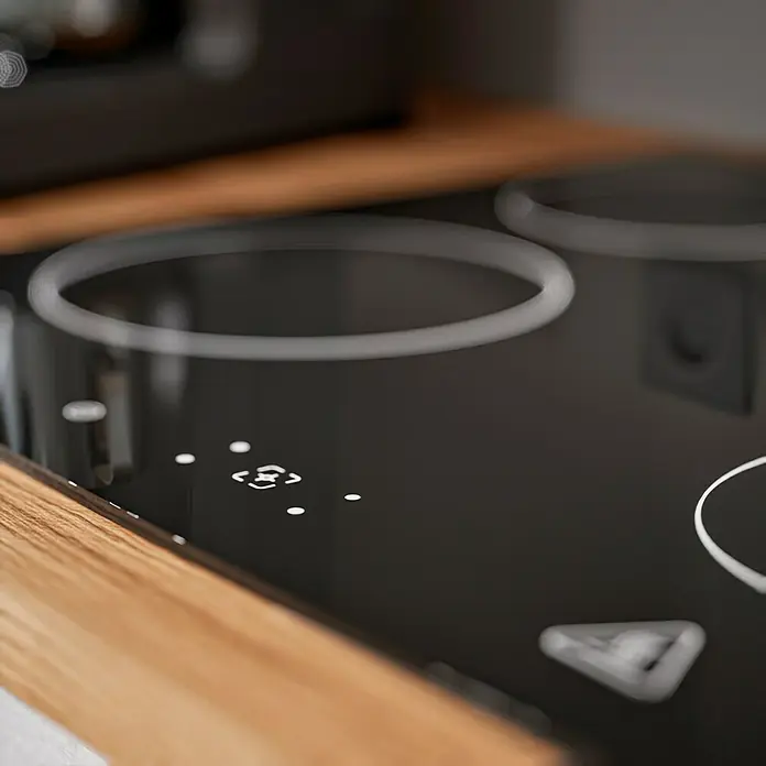 Respekta Composición de cocina Hilde - Ancho: 280 cm, Gris, Con electrodomésticos - Primer plano de una moderna placa de inducción negra sobre una encimera de madera, destacando sus controles y zonas de cocción.