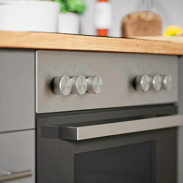 Respekta Composición de cocina Hilde - Ancho: 250 cm, Gris, Con electrodomésticos - Primer plano de un horno gris moderno con pomos y manija plateados, situado en una cocina luminosa.